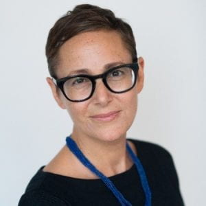 Woman in glasses smiles at camera