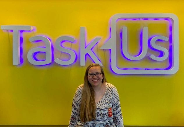 Brooke Reaves in front of TaskUs Logo