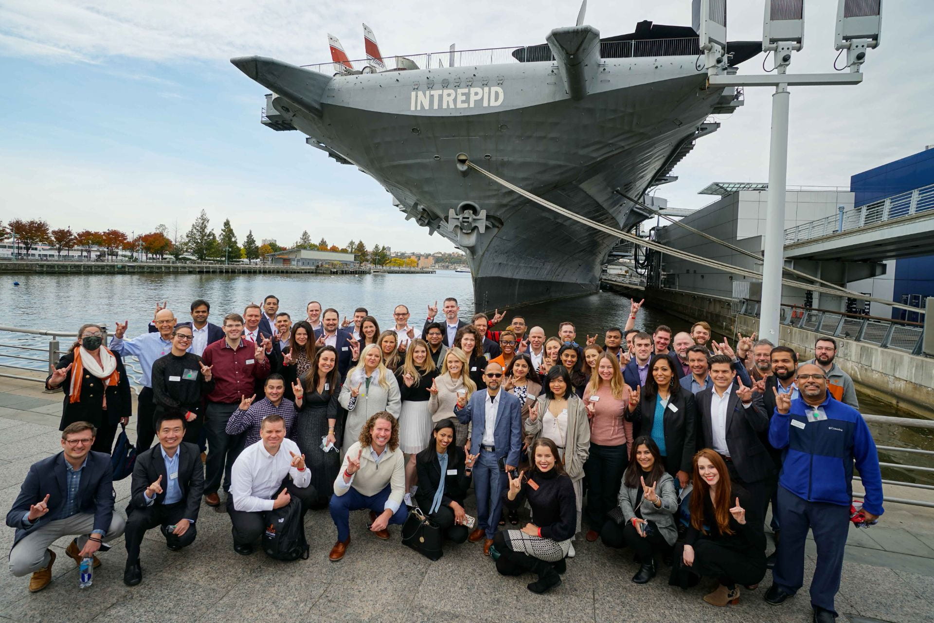 students standing in front of the Intrepid ship