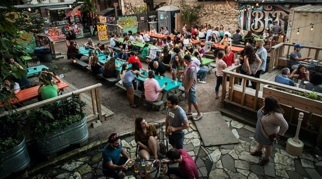 A large back-patio filled with people enjoying drinks